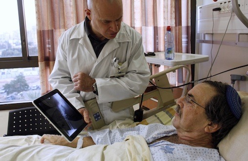Doctor Nir Cohen shows a patient an x-ray image on an Apple iPad at the Mayanei Hayeshua Medical Center in Bnei Brak
